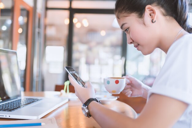 mujer con hermosa sonrisa leyendo buenas noticias en el teléfono móvil