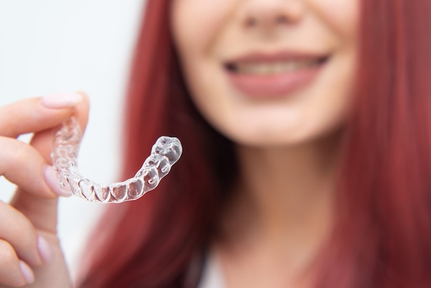 Mujer con una hermosa sonrisa muestra un protector bucal transparente