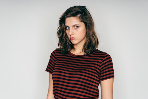 Mujer hermosa sospechosamente joven en ropa casual posando en el estudio