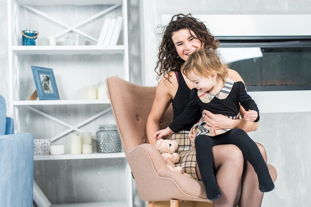 La mujer hermosa y su pequeña hija linda están soplando burbujas de jabón