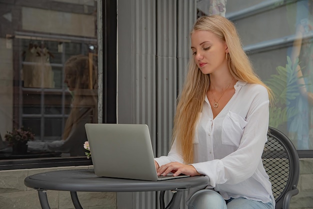 Una mujer hermosa usa un cuaderno para enviar un correo electrónico al cliente o hacer compras en línea