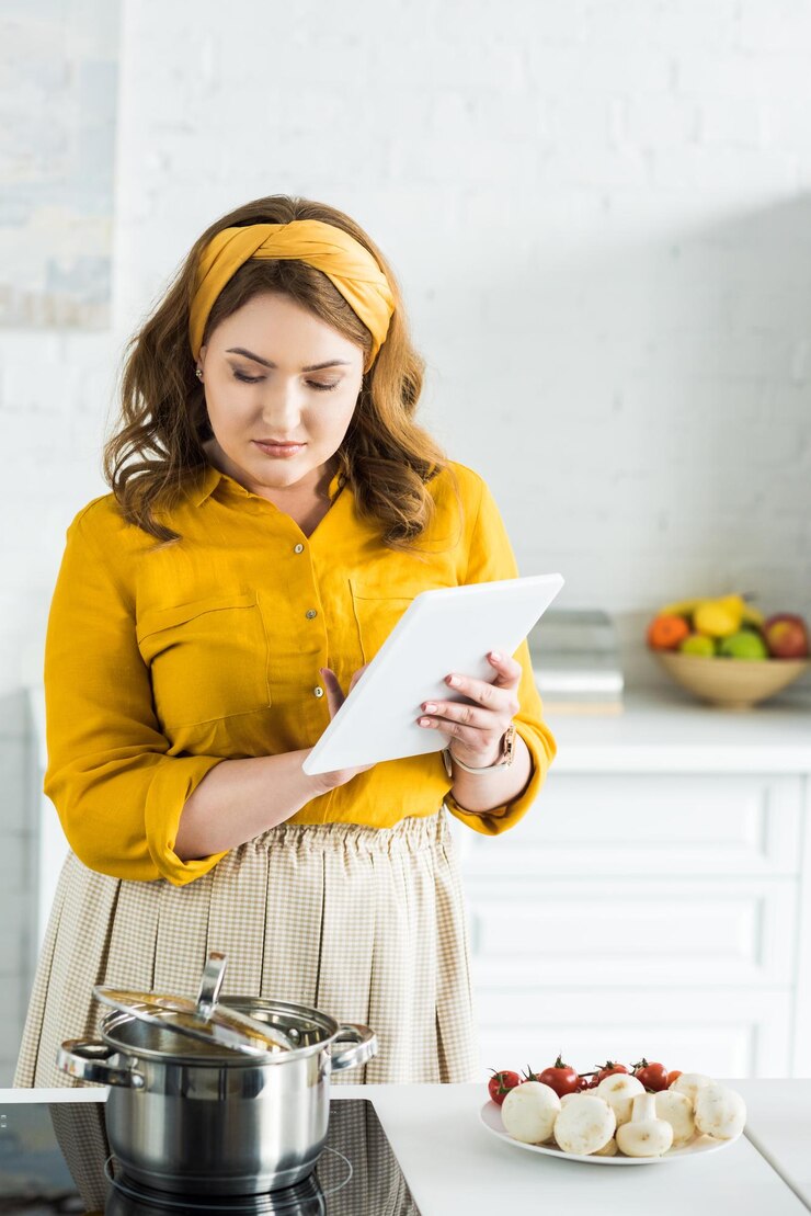 Foto una mujer hermosa usando una tableta en la cocina.