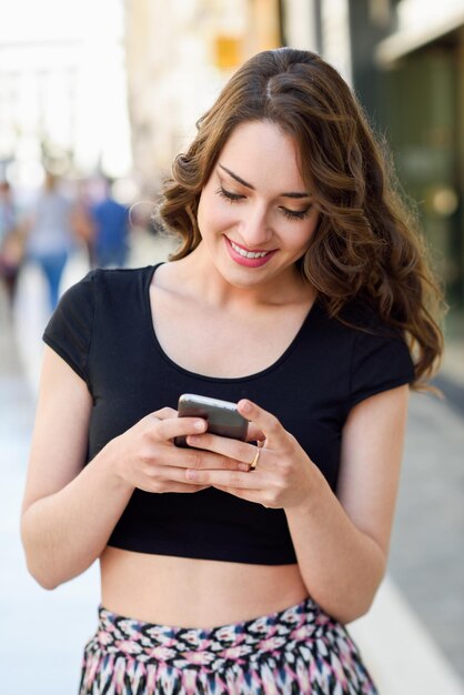 Foto mujer hermosa usando el teléfono en la calle