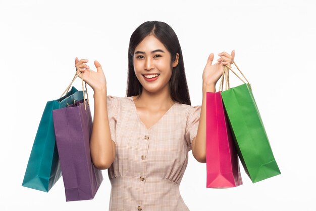 Mujer hermosa en un vestido con bolsas de compras