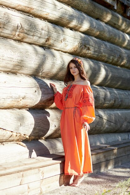 Mujer hermosa en un vestido naranja con una corona