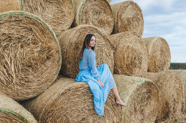 Mujer hermosa en un vestido de pajar.