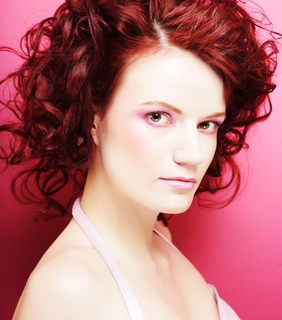 Mujer con hermoso maquillaje y cabello rizado rojo