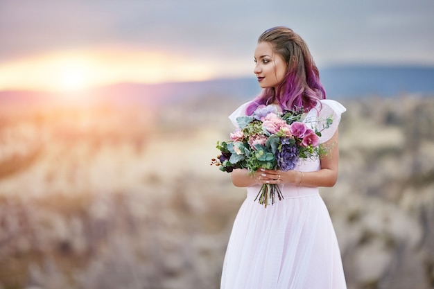 Mujer con un hermoso ramo de flores en sus manos está parado