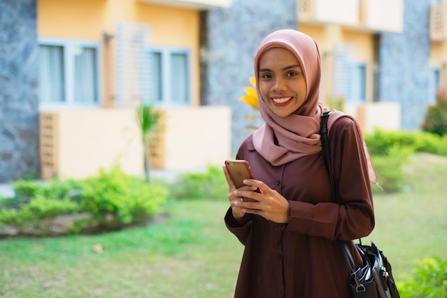 Foto una mujer con hijab y un cuaderno en la mano