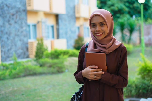 Foto una mujer con un hijab con un cuaderno en la mano