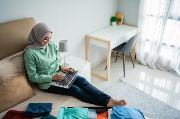 Mujer hijab que comprueba los horarios de salida a través de la aplicación en línea