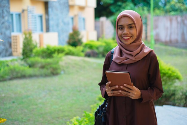 una mujer con un hijab con una tableta en sus manos