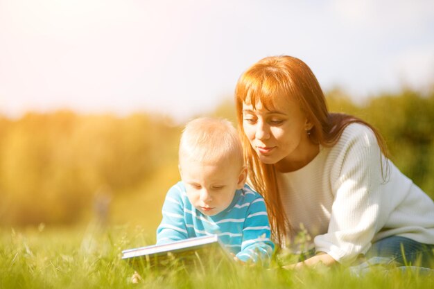 Mujer con hijo sentado y leer cuento de hadas