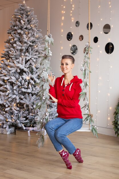 Mujer hipster cerca del árbol de Navidad, año nuevo