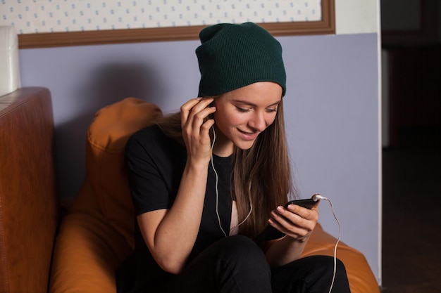 Mujer hipster escuchando música en café