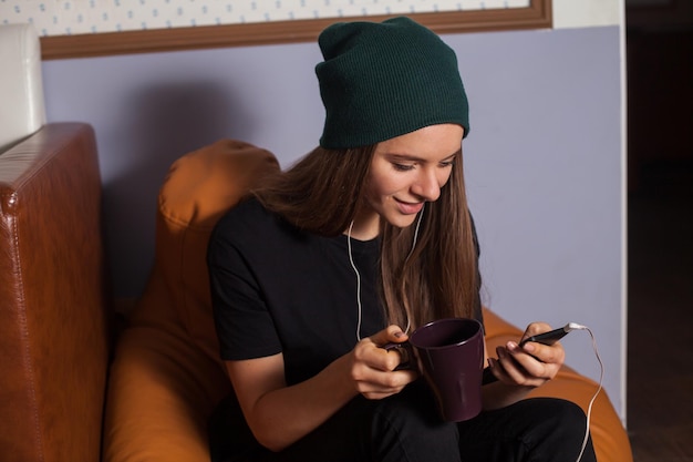 Mujer hipster escuchando música en café