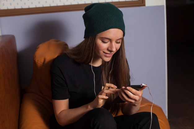 Mujer hipster escuchando música en café