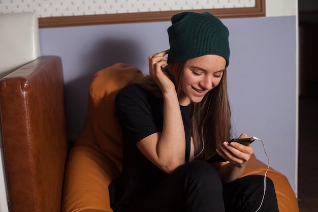 Mujer hipster escuchando música en café