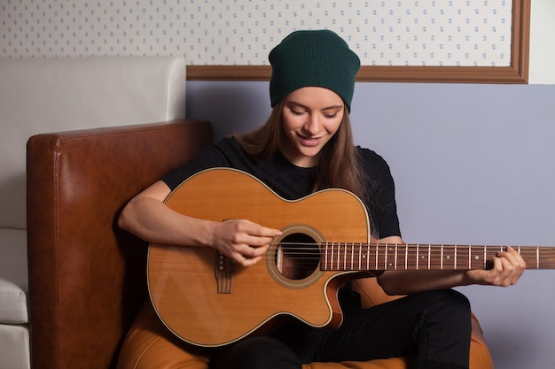 Mujer hipster tocando guitarra y cantando