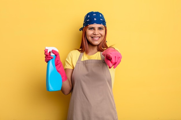 Mujer hispana apuntando a la cámara eligiéndote. concepto de limpieza y ama de llaves