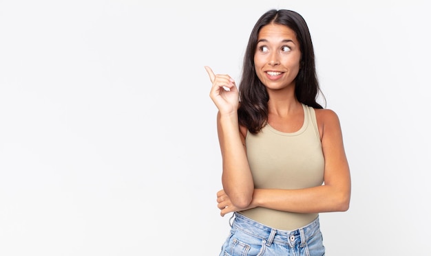 Mujer hispana bastante delgada sonriendo felizmente y mirando hacia los lados, preguntándose