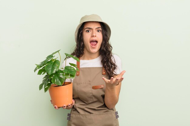 Mujer hispana bonita joven que parece desesperada, frustrada y estresada, concepto de agricultor o jardinero