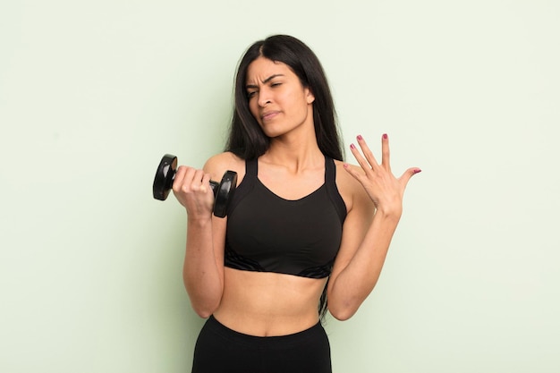 Mujer hispana bonita joven que se siente estresada, ansiosa, cansada y frustrada concepto de fitness