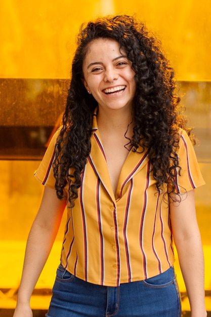 Mujer hispana feliz sonriendo sobre fondo amarillo