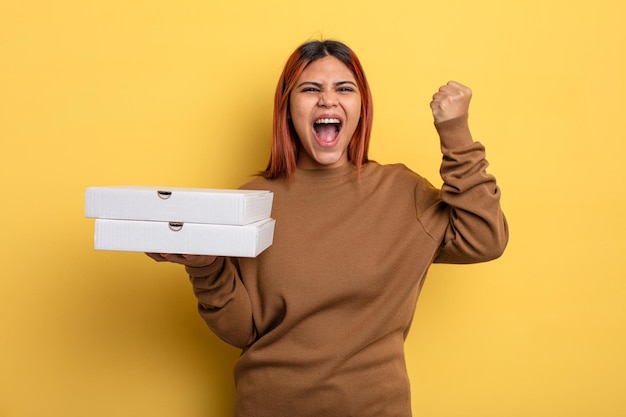 Mujer hispana gritando agresivamente con una expresión enojada. concepto de pizzas para llevar