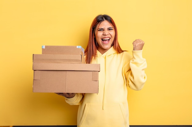 Mujer hispana gritando agresivamente con una expresión de enojo. concepto de cajas de envío