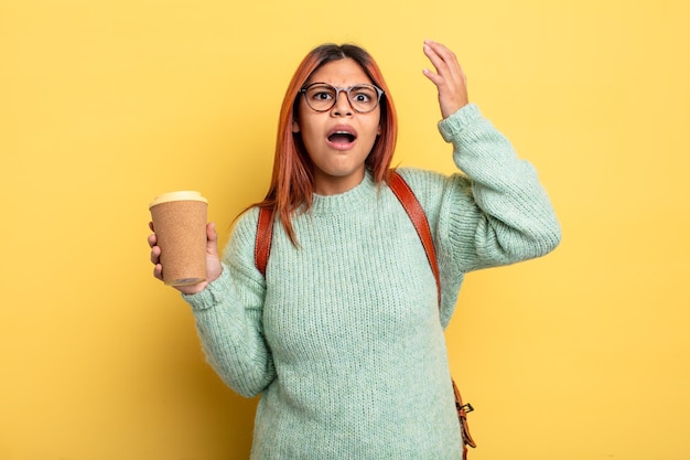 Mujer hispana gritando con las manos en el aire estudiante con un concepto de café