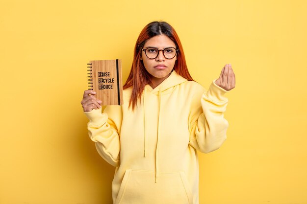 Mujer hispana haciendo capice o gesto de dinero, diciéndole que pague. concepto de reciclaje