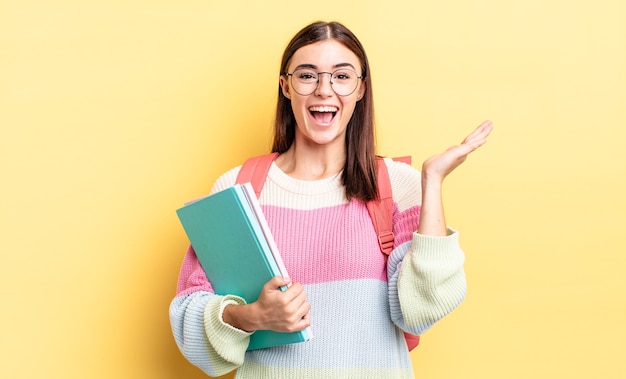 Mujer hispana joven que se siente feliz y asombrada por algo increíble. concepto de estudiante