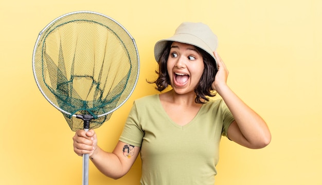 Mujer hispana joven que se siente feliz, emocionada y sorprendida. concepto de red de pescadores