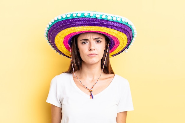 Mujer hispana joven que se siente triste y llorona con una mirada infeliz y llorando. concepto de sombrero mexicano