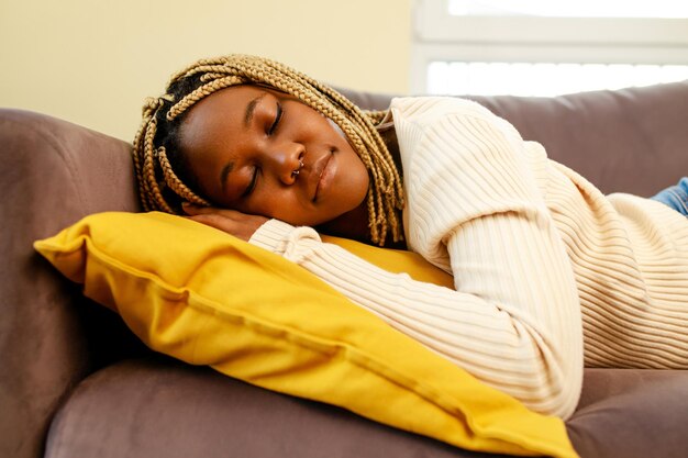 Mujer hispana latina cansada tomando siesta en el sofá durante el día