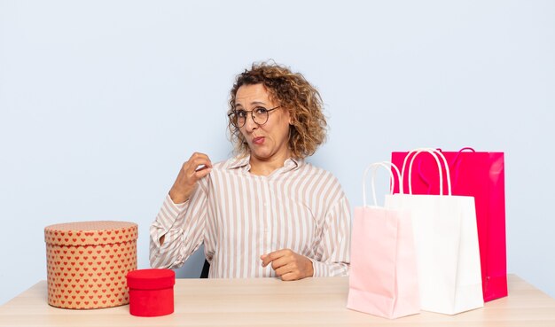 Mujer hispana de mediana edad que parece arrogante, exitosa, positiva y orgullosa, apuntando a sí misma