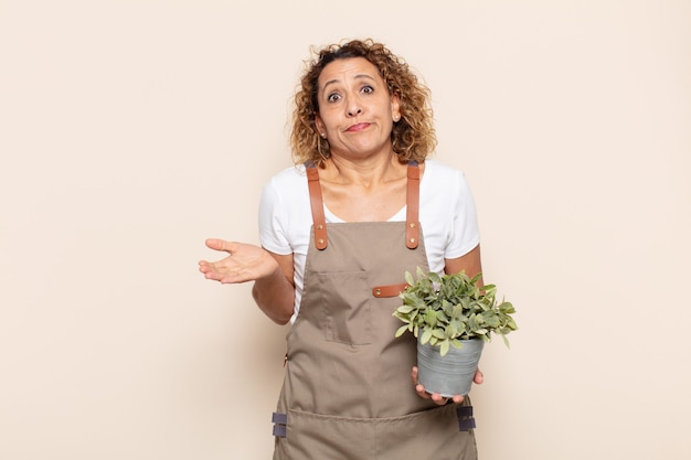 Mujer hispana de mediana edad que se siente perpleja y confundida, dudando, ponderando o eligiendo diferentes opciones con expresión divertida