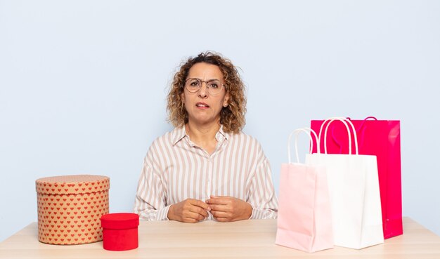 Mujer hispana de mediana edad que se siente perpleja y confundida, con una expresión muda y atónita mirando algo inesperado