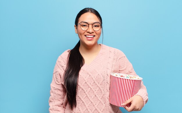 Mujer hispana que parece feliz y gratamente sorprendida, emocionada con una expresión fascinada y conmocionada.