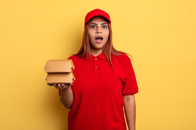 Mujer hispana que parece muy conmocionada o sorprendida. llevar el concepto de entrega