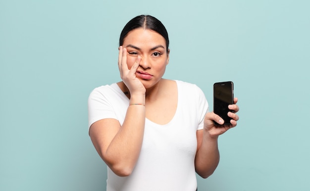 Mujer hispana que se siente aburrida, frustrada y somnolienta después de una tarea aburrida, aburrida y tediosa.