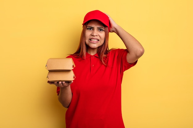 Mujer hispana que se siente estresada, ansiosa o asustada, con las manos en la cabeza. llevar el concepto de entrega