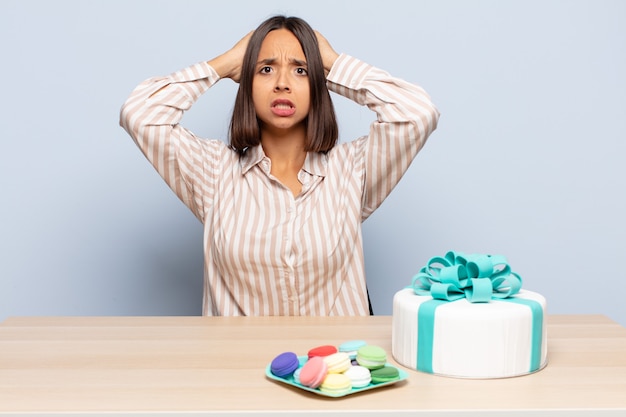 Mujer hispana que se siente estresada, preocupada, ansiosa o asustada, con las manos en la cabeza, presa del pánico por el error