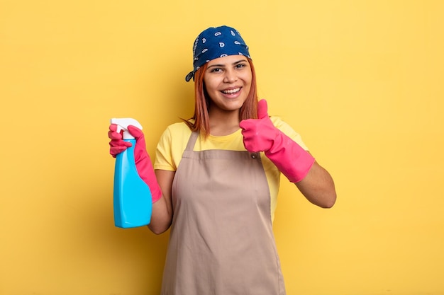 Mujer hispana que se siente orgullosa sonriendo positivamente con los pulgares hacia arriba limpiando y el concepto de ama de llaves