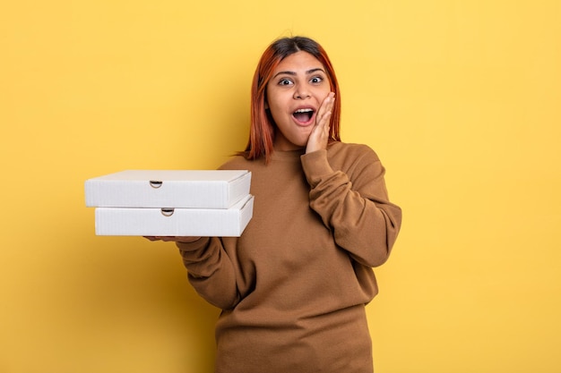 Mujer hispana que se siente sorprendida y asustada para llevar el concepto de pizzas