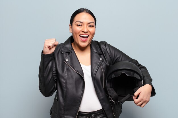 Mujer hispana que se siente sorprendida, emocionada y feliz, riendo y celebrando el éxito, diciendo ¡guau!