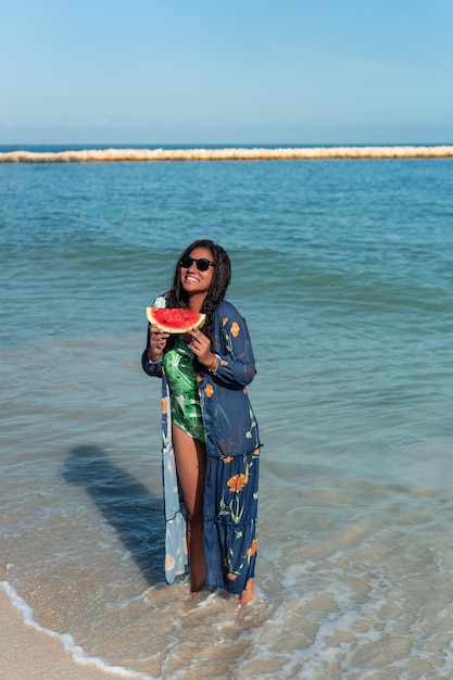 Mujer hispana, tenencia, sandía, en la playa