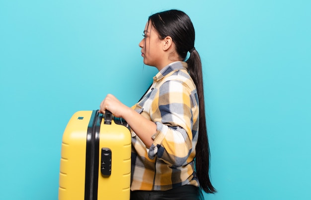 Mujer hispana en vista de perfil mirando para copiar el espacio por delante, pensando, imaginando o soñando despierto