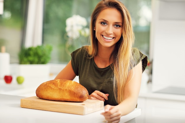 mujer con hogaza de pan en la cocina